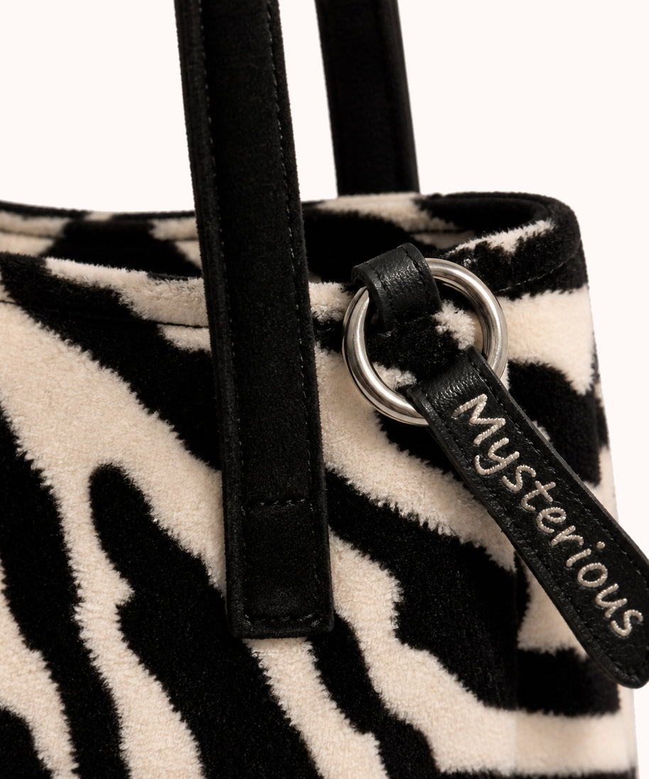 ARIPPULA FEF9F6 | zebra-plush-tote | hardware detail | 065__zebra-plush-tote__hardware-detail.webp