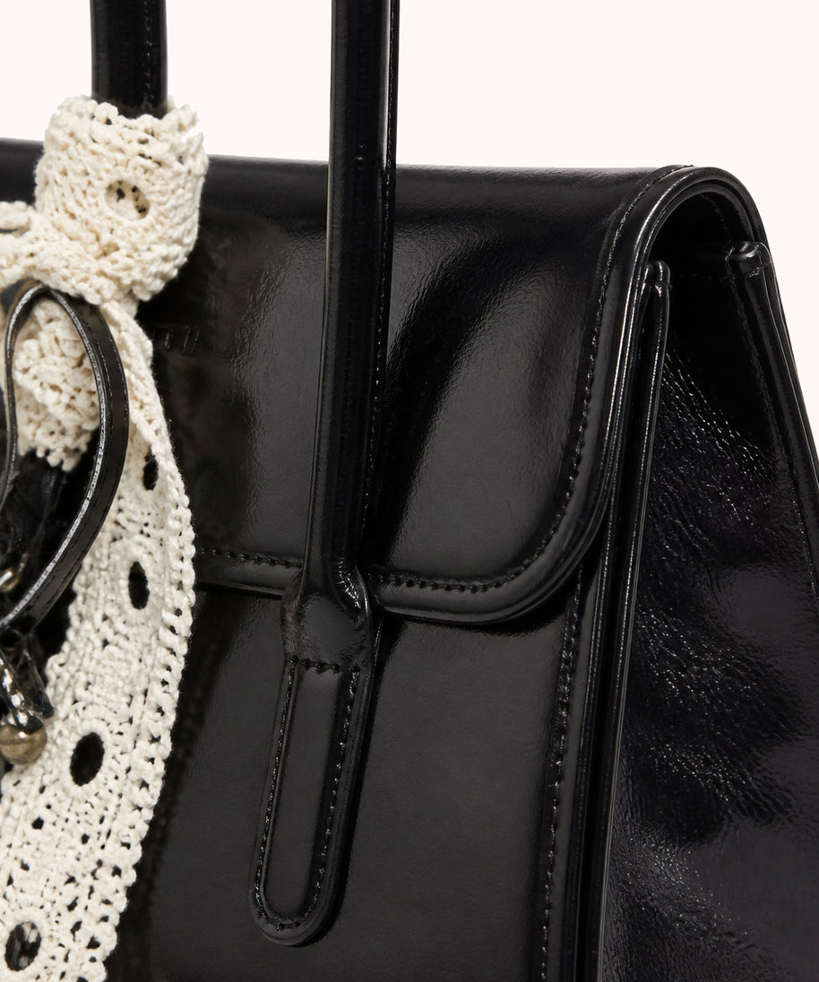 ARIPPULA FEF9F6 | noir-patent-handbag | hardware detail | 121__noir-patent-handbag__hardware-detail.webp