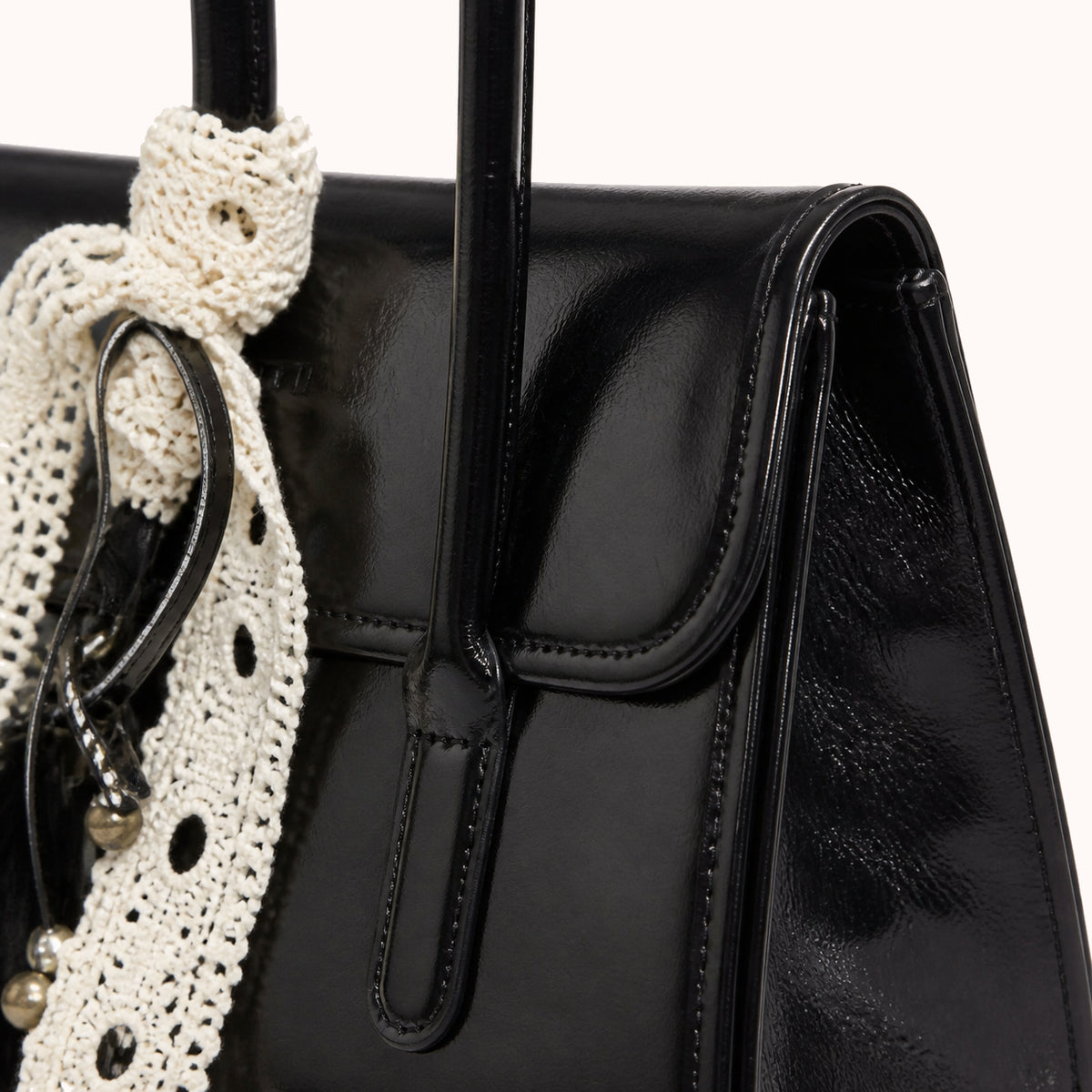 ARIPPULA FEF9F6 | noir-patent-handbag | hardware detail | 121__noir-patent-handbag__hardware-detail.webp