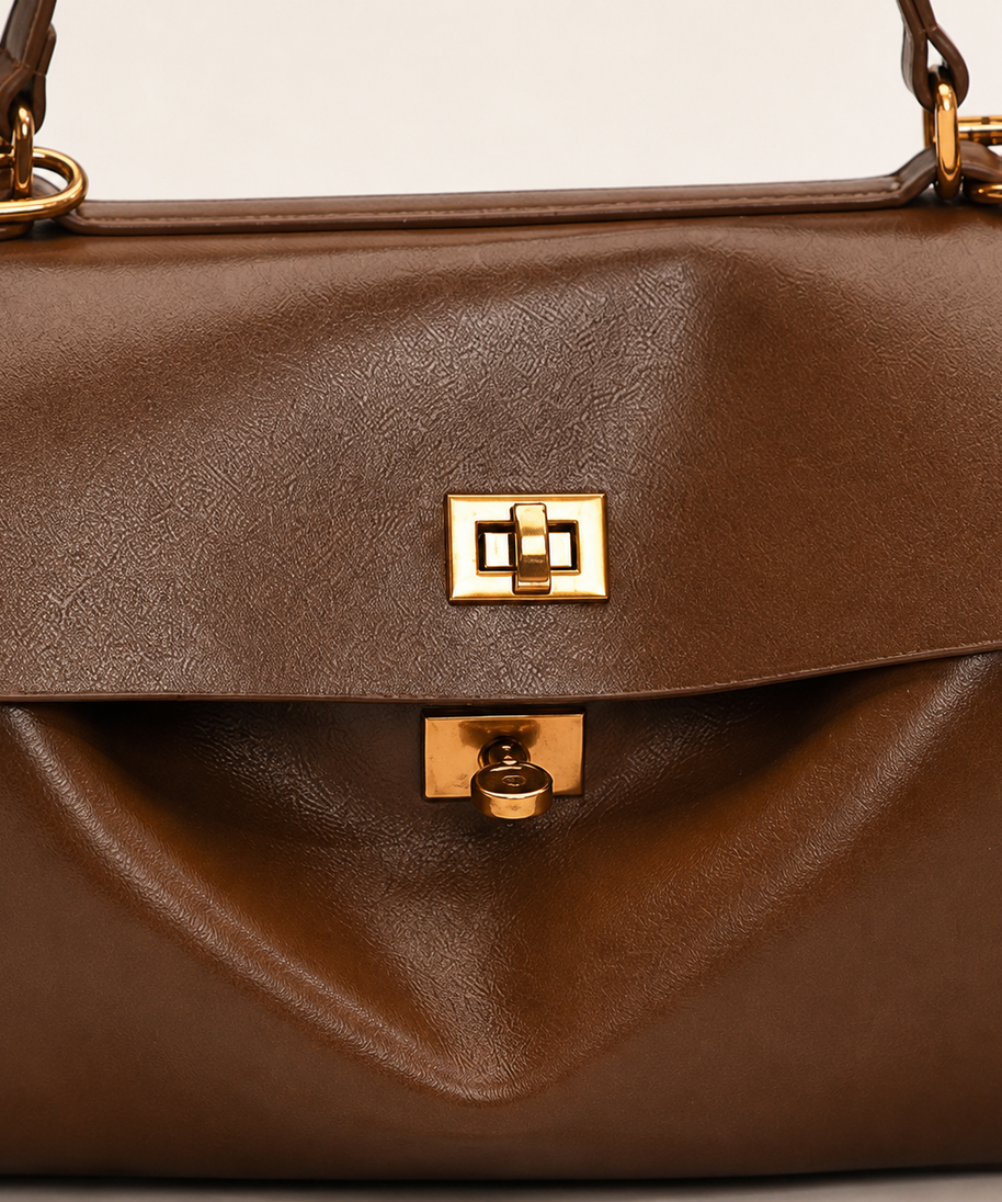 Audrey satchel front flap and gold turn-lock hardware detail