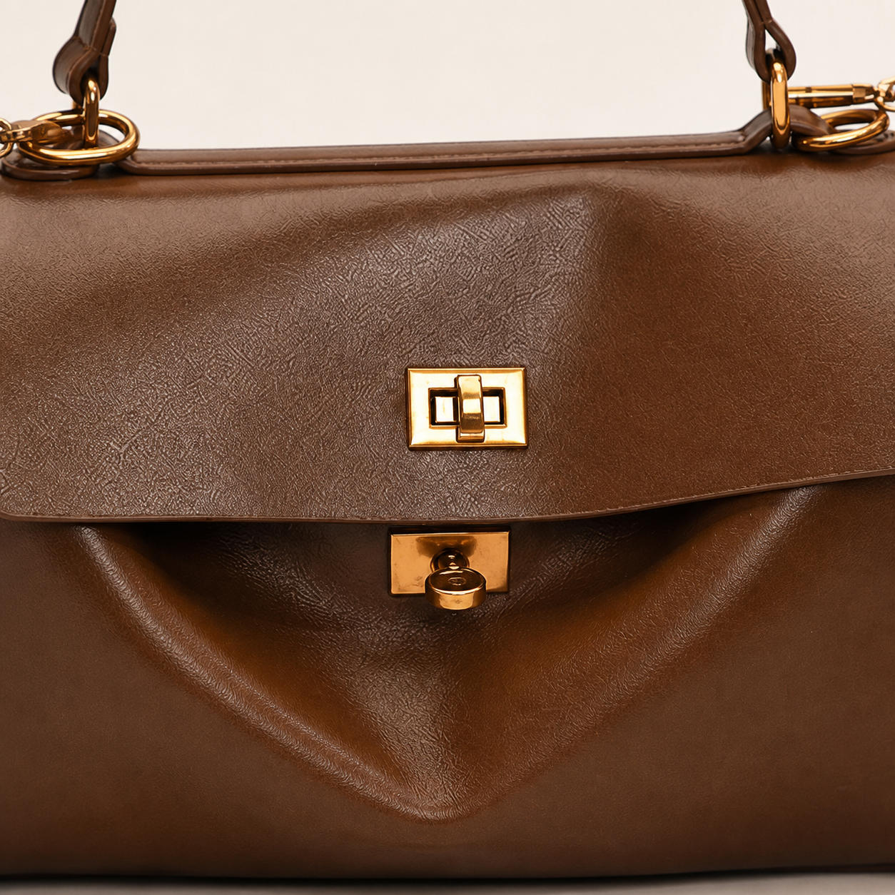 Audrey satchel front flap and gold turn-lock hardware detail